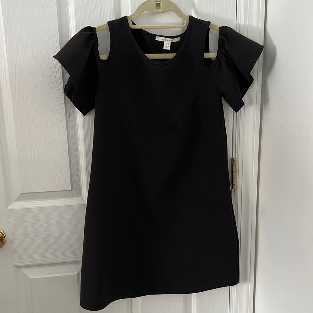 Black dress with open shoulder and ruffle detail